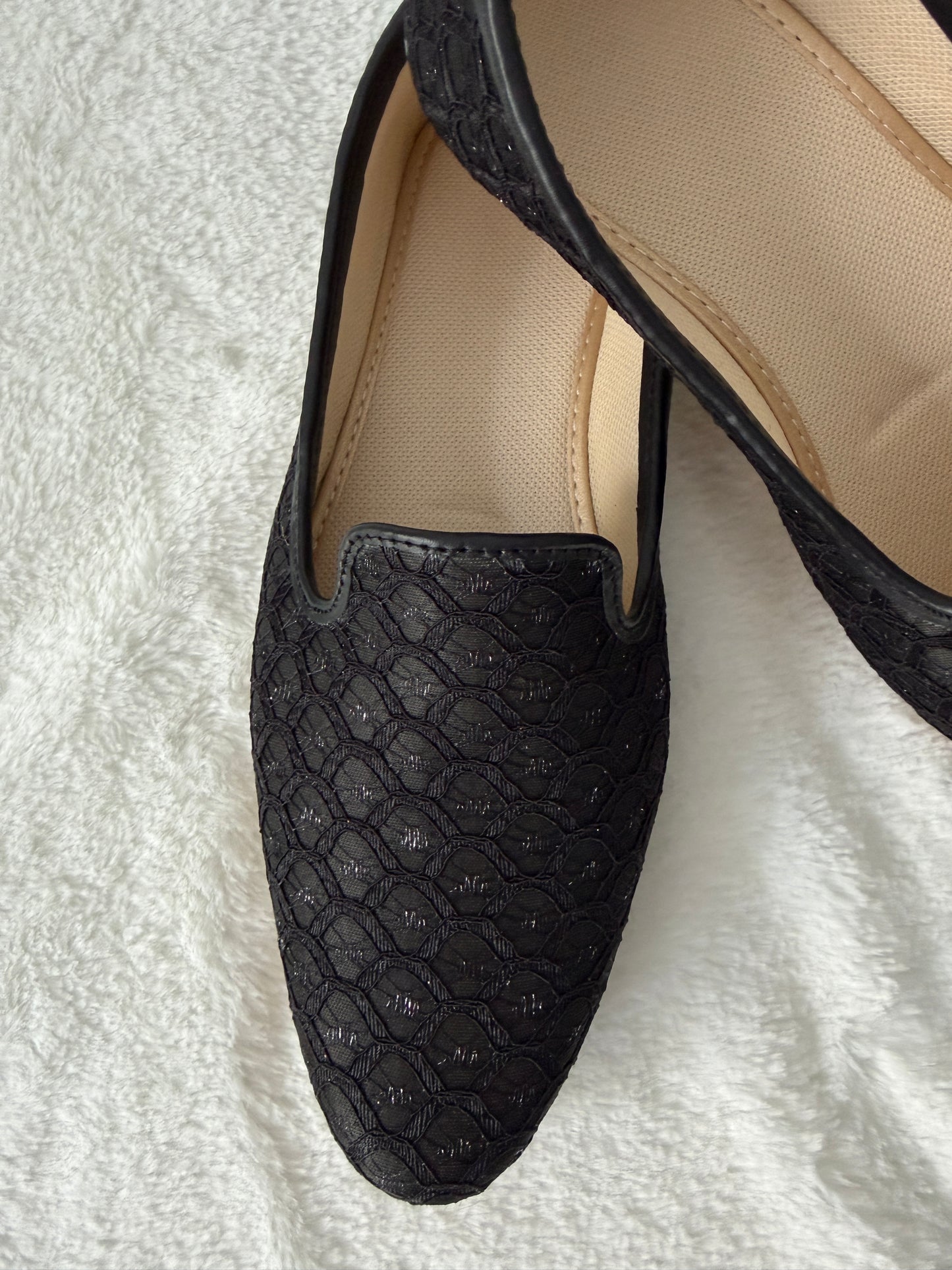 Black textured loafers on a white background