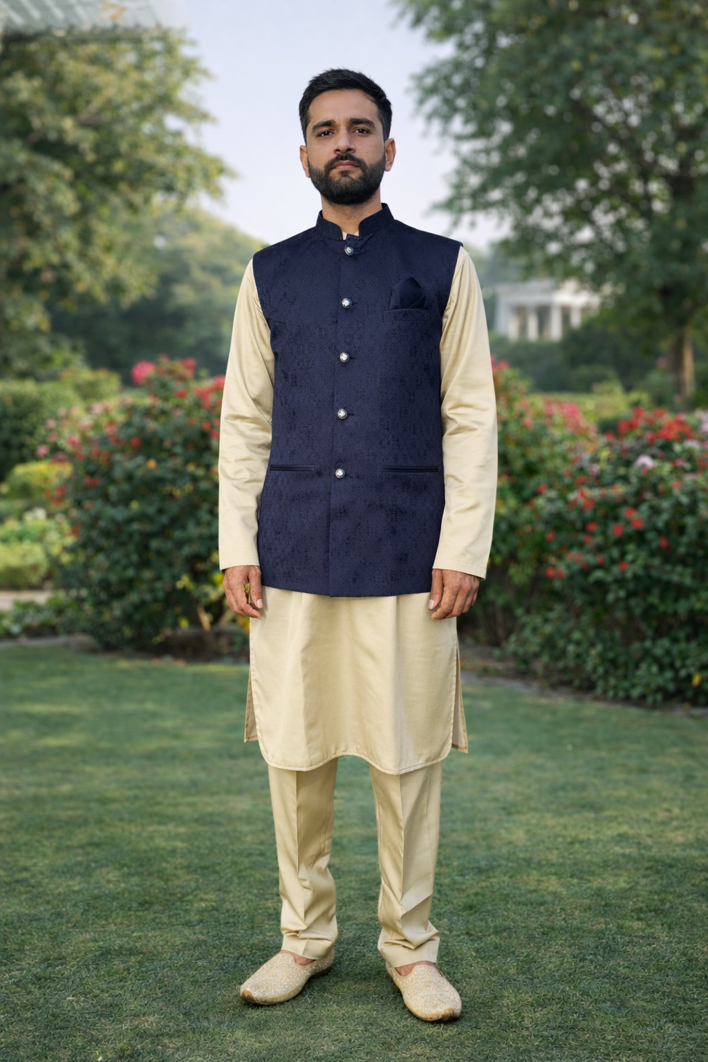 Man wearing a traditional outfit with a navy vest in an outdoor setting