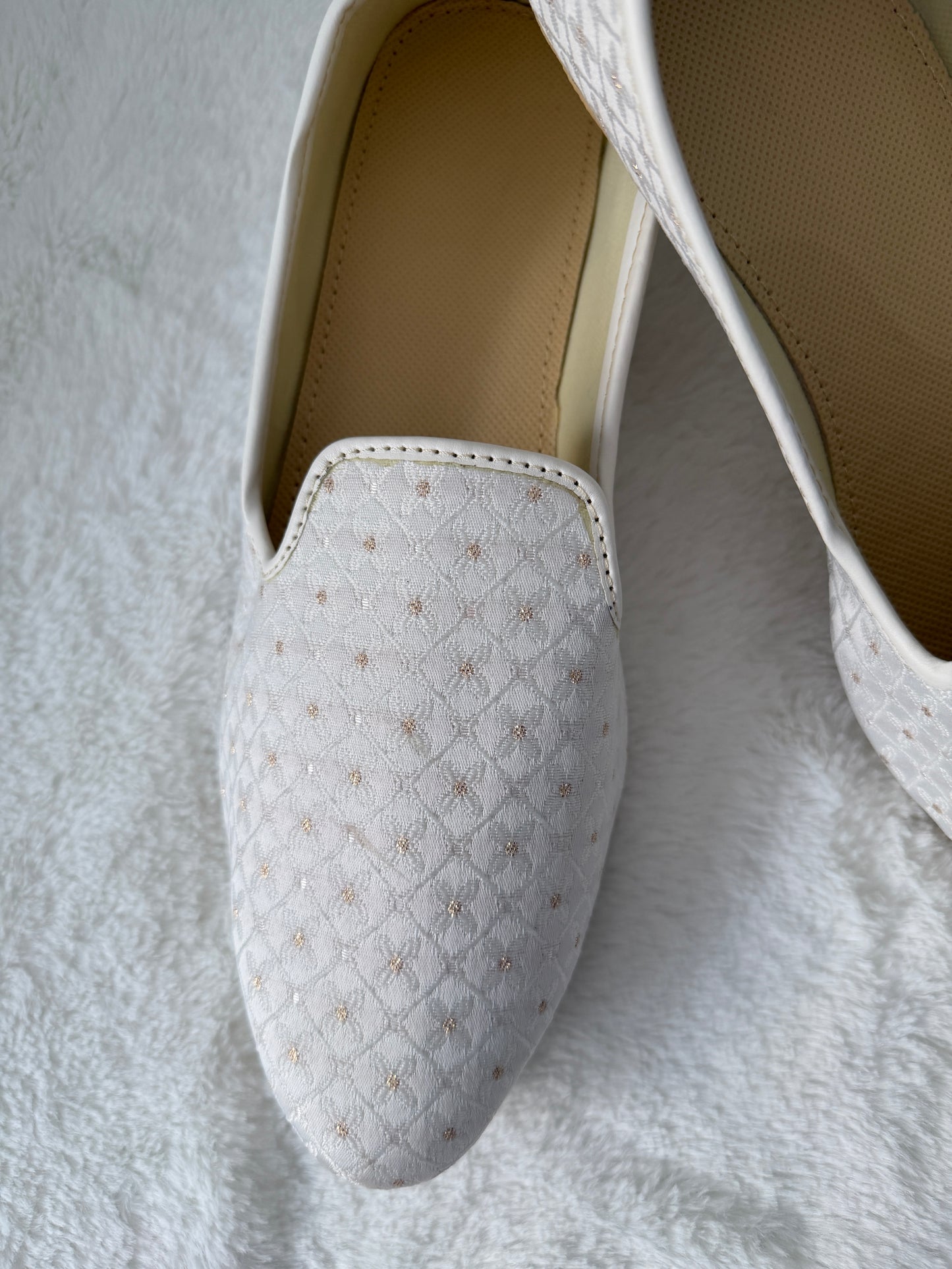 White Jutti with textured pattern on a white background