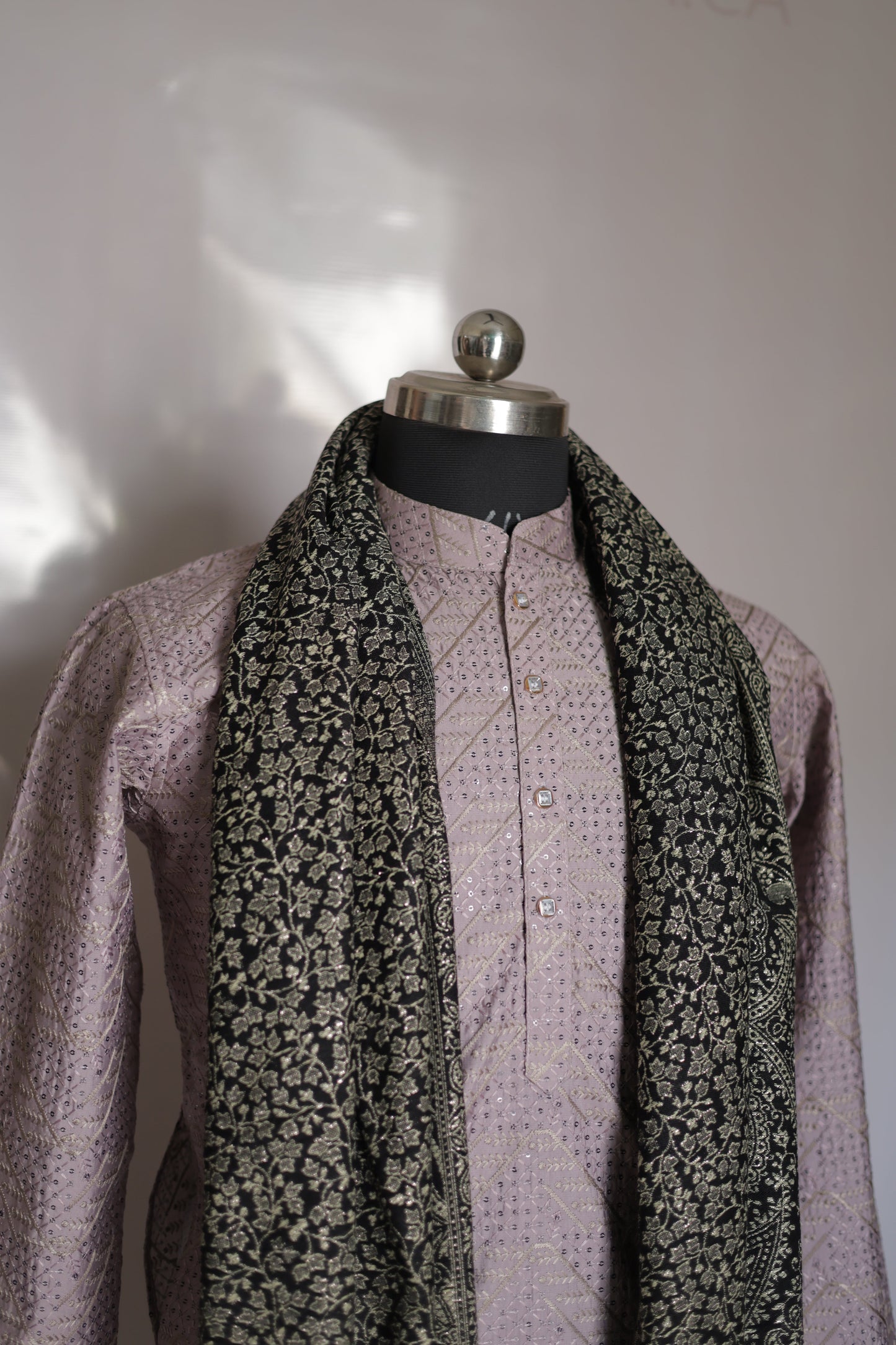 Close-up of a folded fabric with floral pattern and purple border on a white background