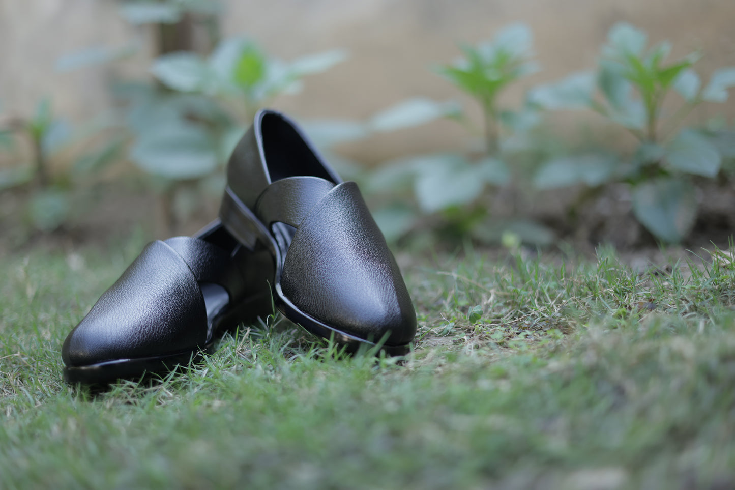 Black shoes on grass with a blurred background