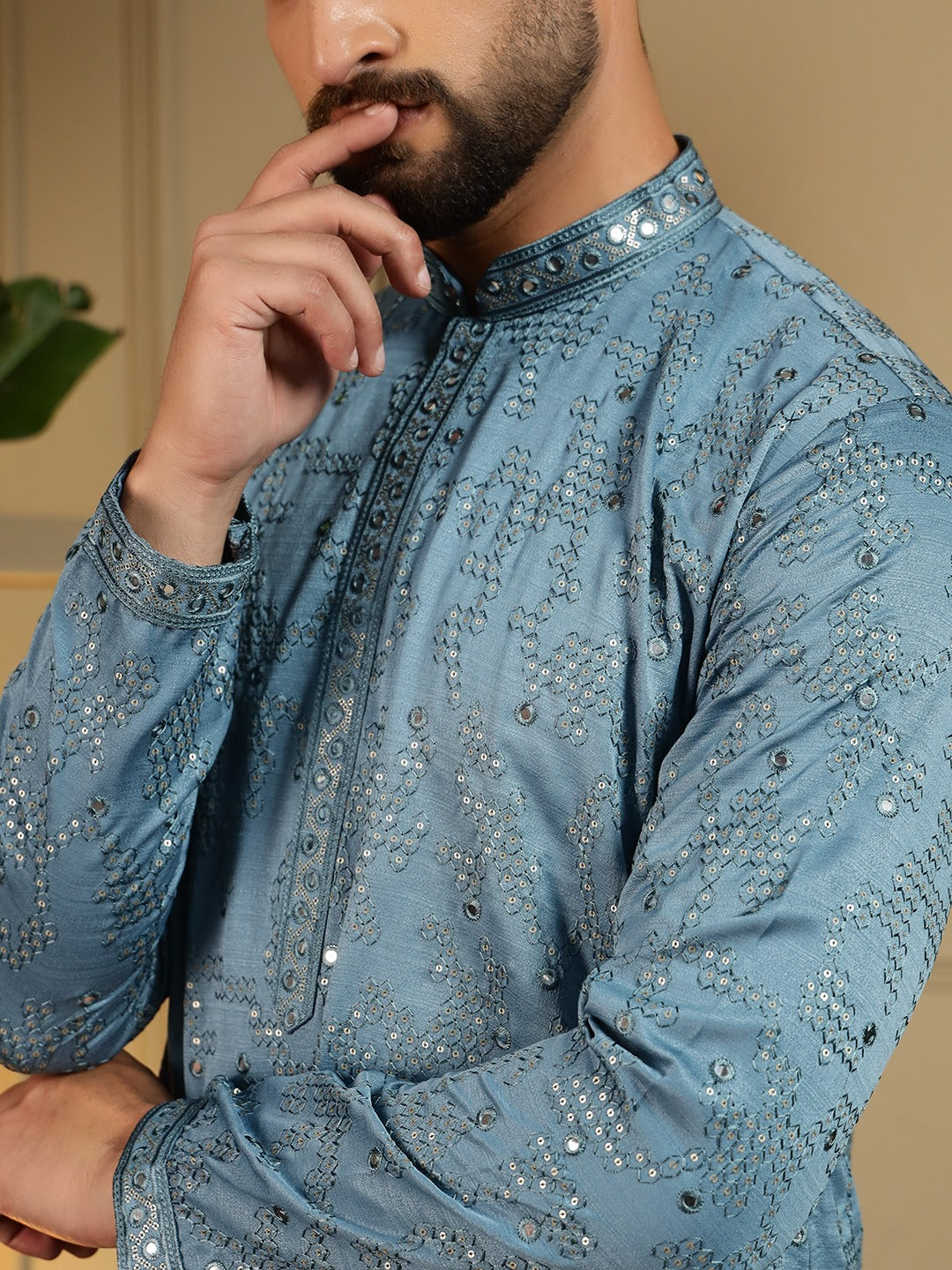 Man wearing a blue kurta with intricate patterns.