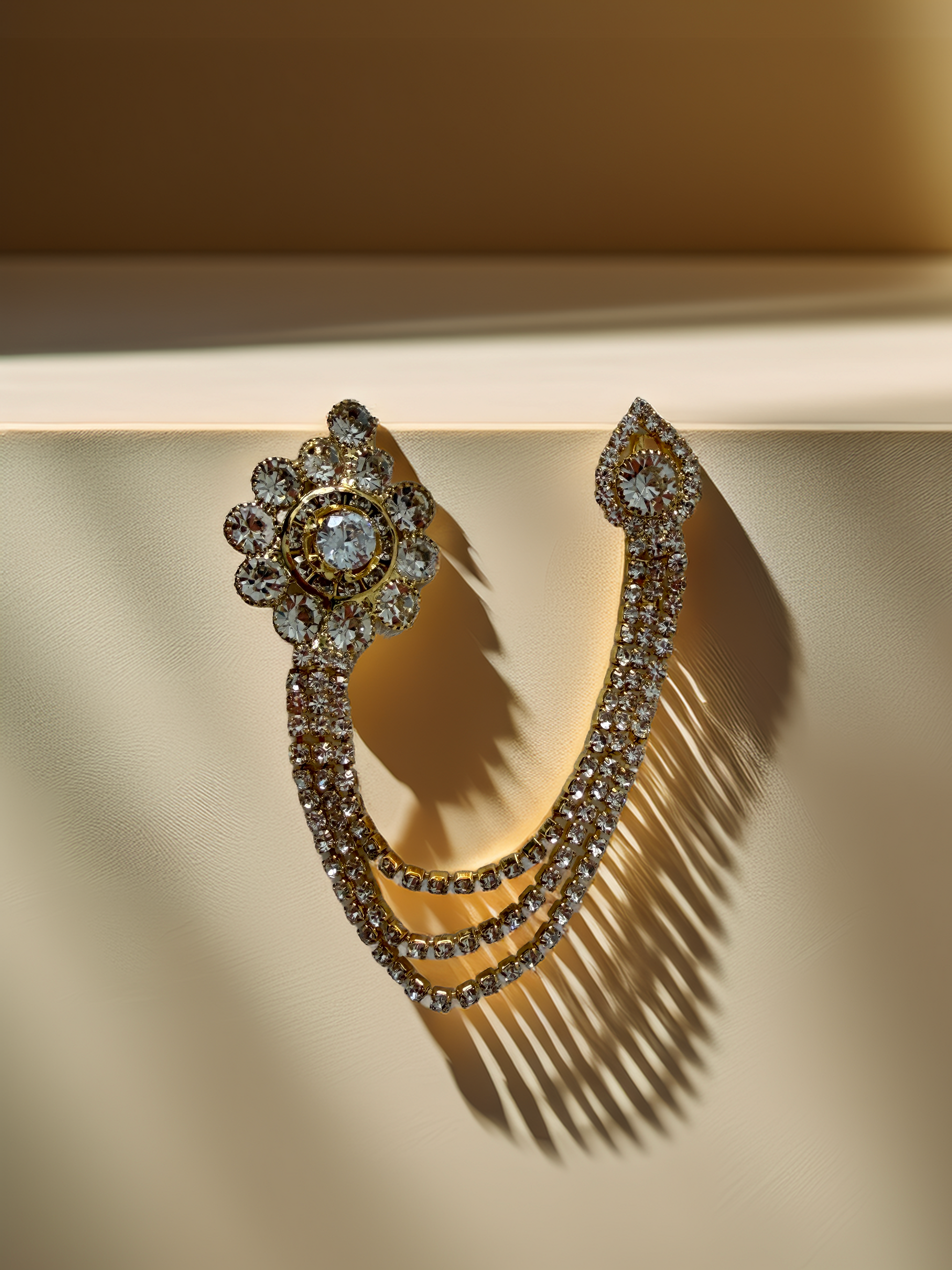 Ornate earring with gemstones on a beige background