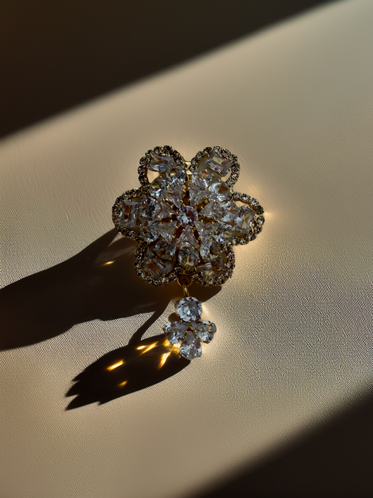Diamond flower brooch on a beige fabric background