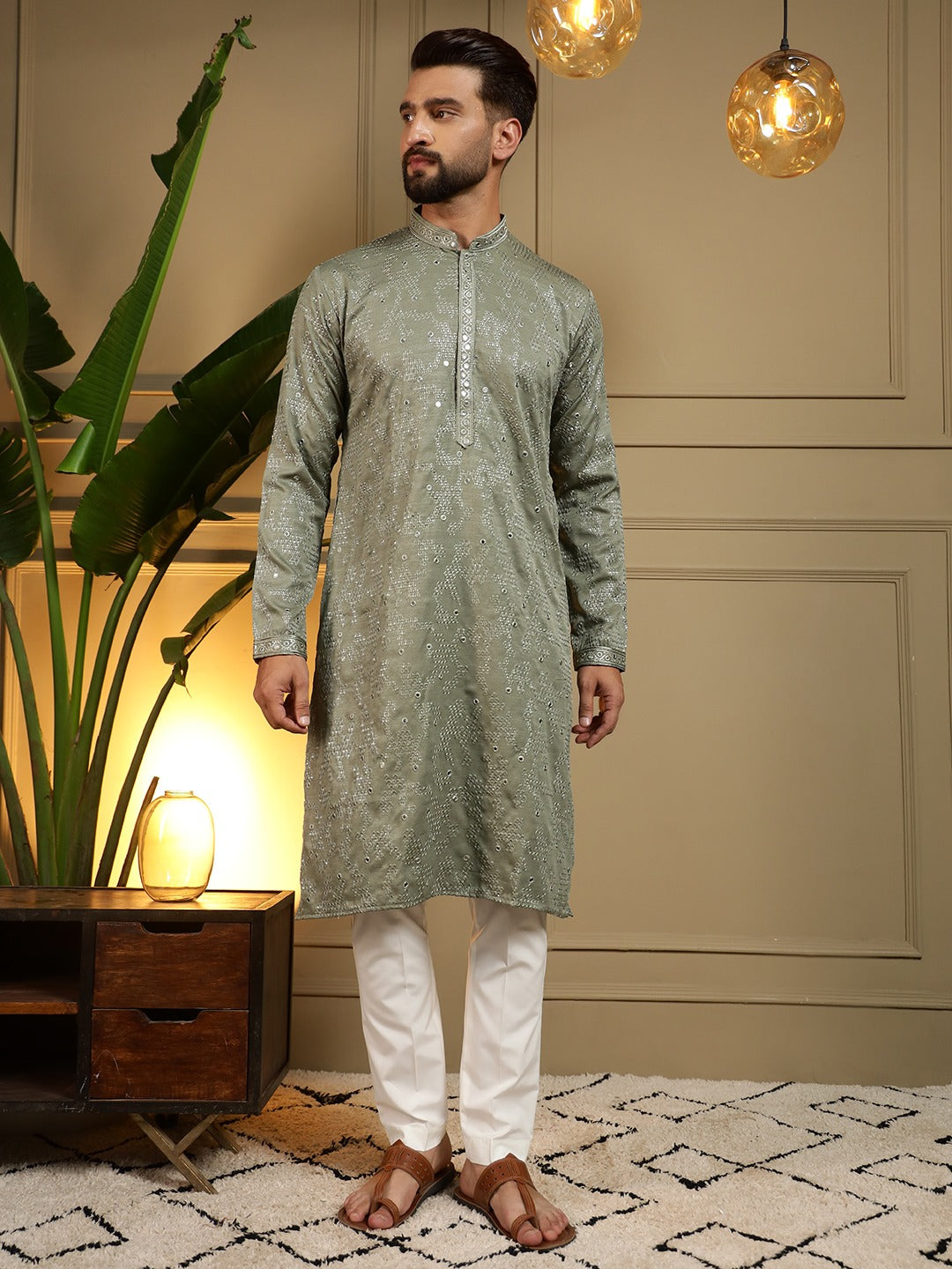 Man wearing a green kurta with white pyjama in an indoor setting.