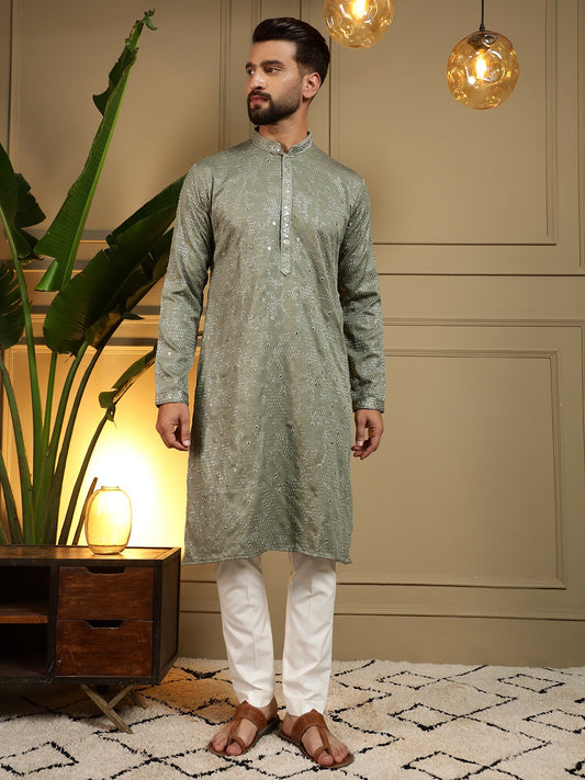 Man wearing a green kurta with white pyjama in an indoor setting.
