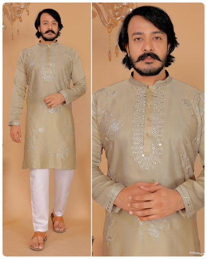 Man wearing a beige embroidered kurta with white pants on a beige background