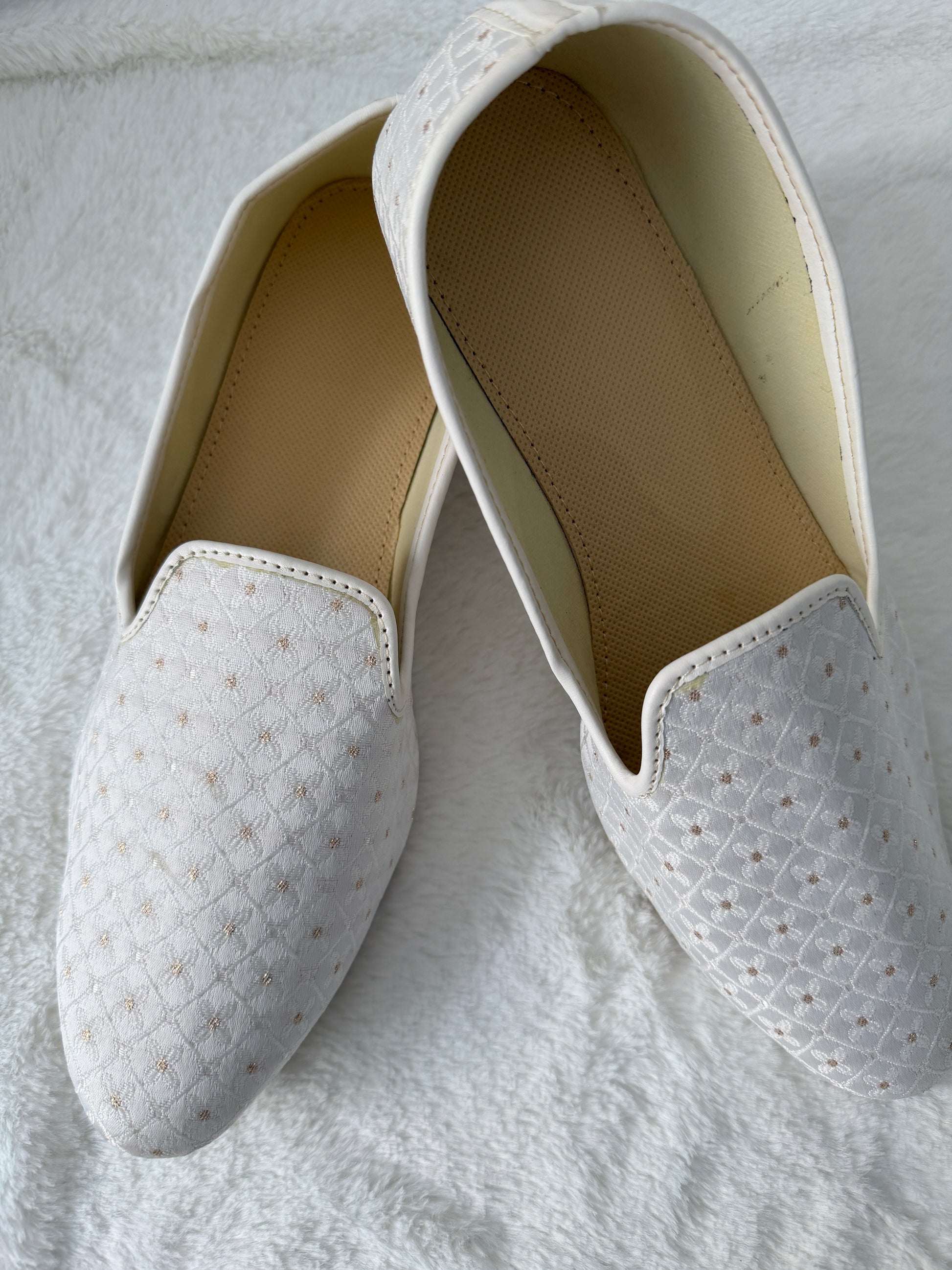 White Jutti with textured pattern on a light gray background