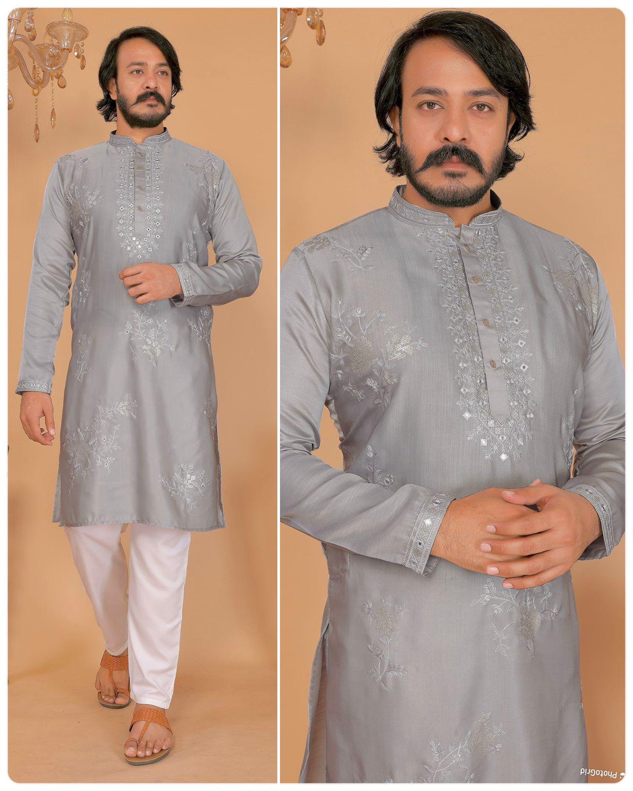 Man wearing a gray embroidered kurta with white pants against a beige background