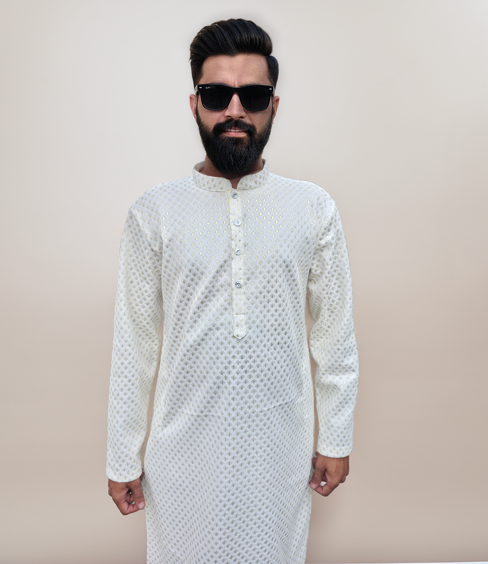 Man wearing a white kurta with a subtle pattern against a beige background