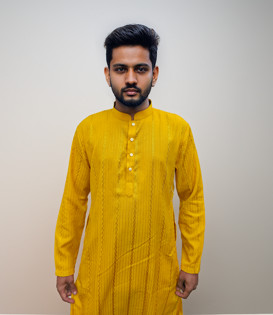 Man wearing a dark patterned kurta with white pants on a beige background